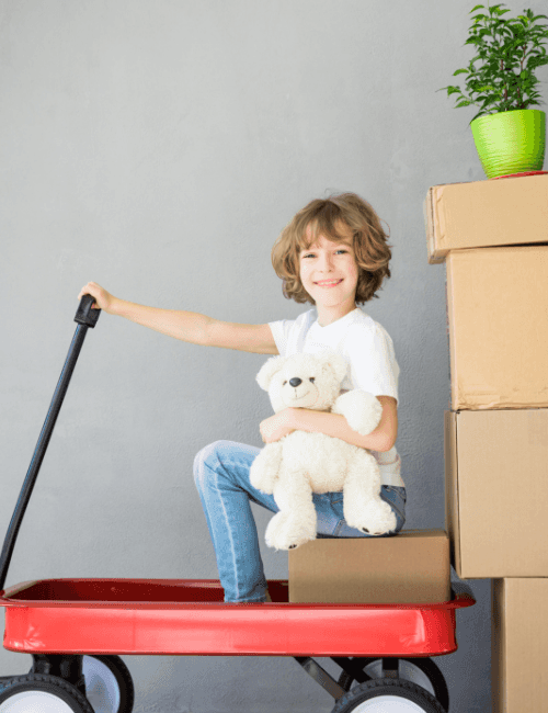 barn bredvid flyttkartonger efter flyttstäd